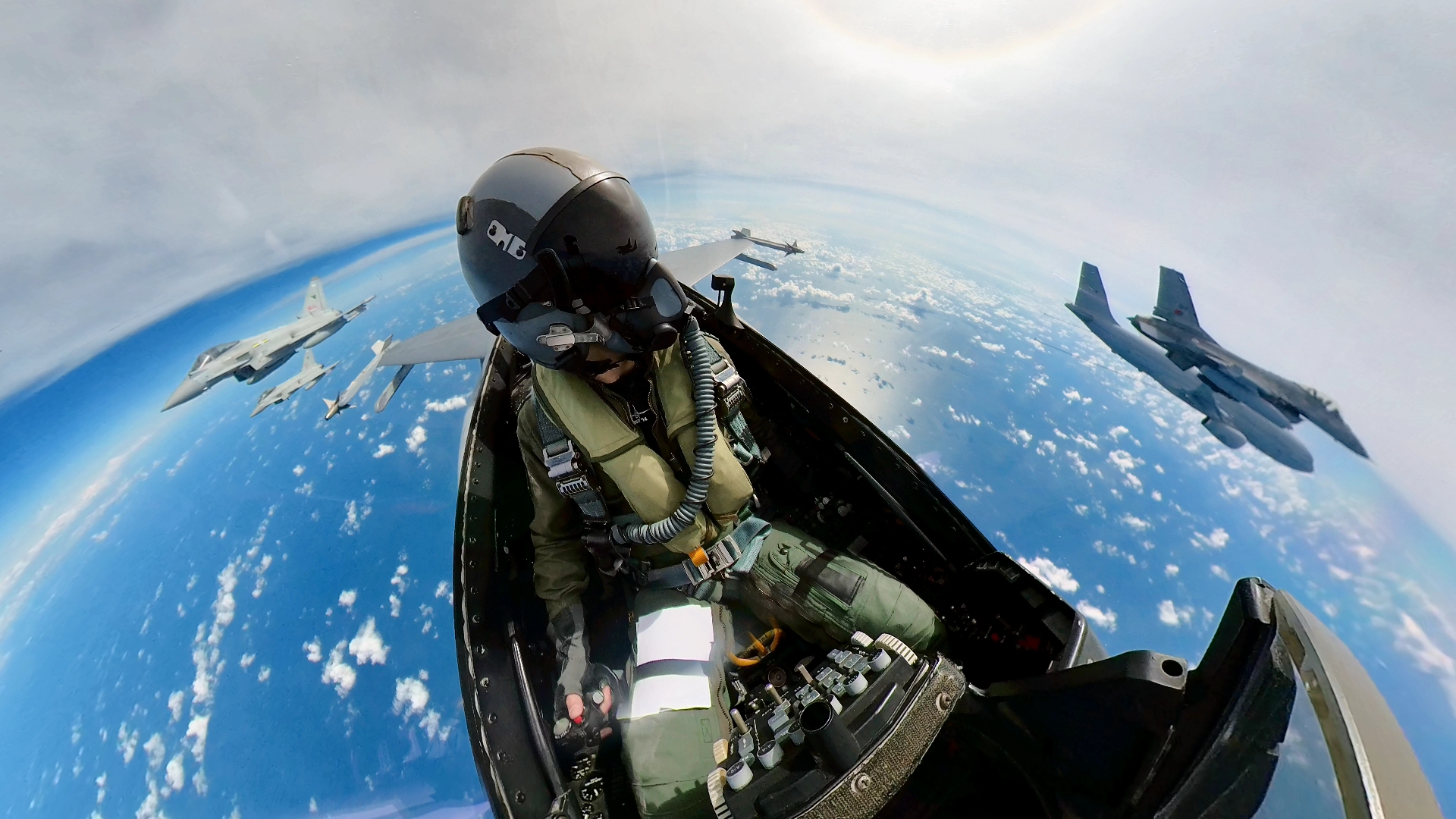 Pilot in cockpit with Typhoons and Voyager aircraft flying in formation.